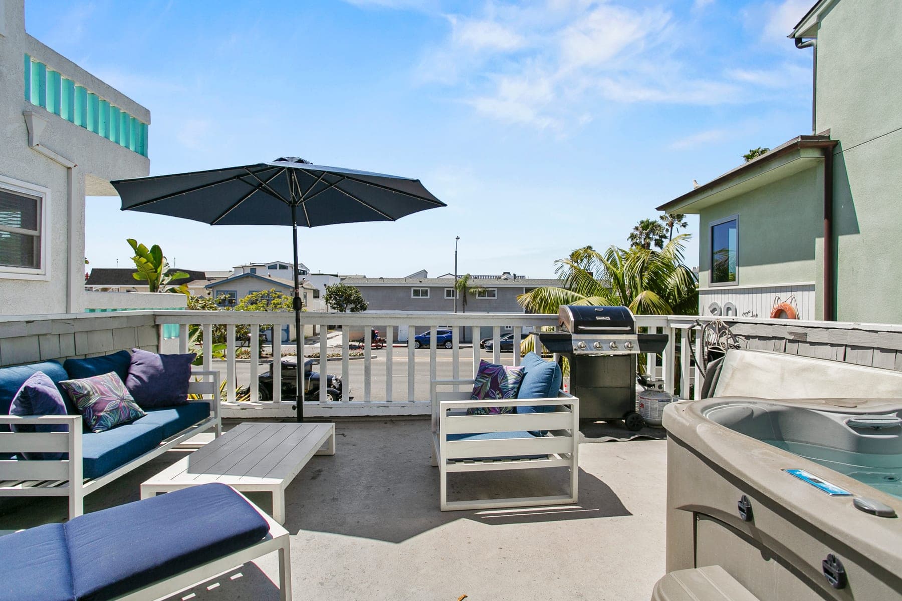 Outdoor deck with dining table, lounge chairs, and umbrella
