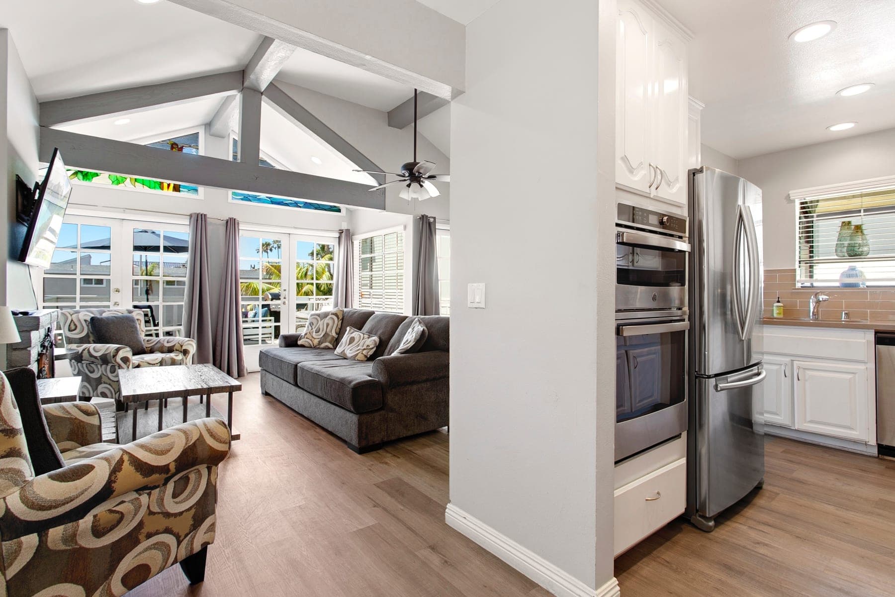 Bright Newport Beach living room with balcony doors and vaulted ceilings