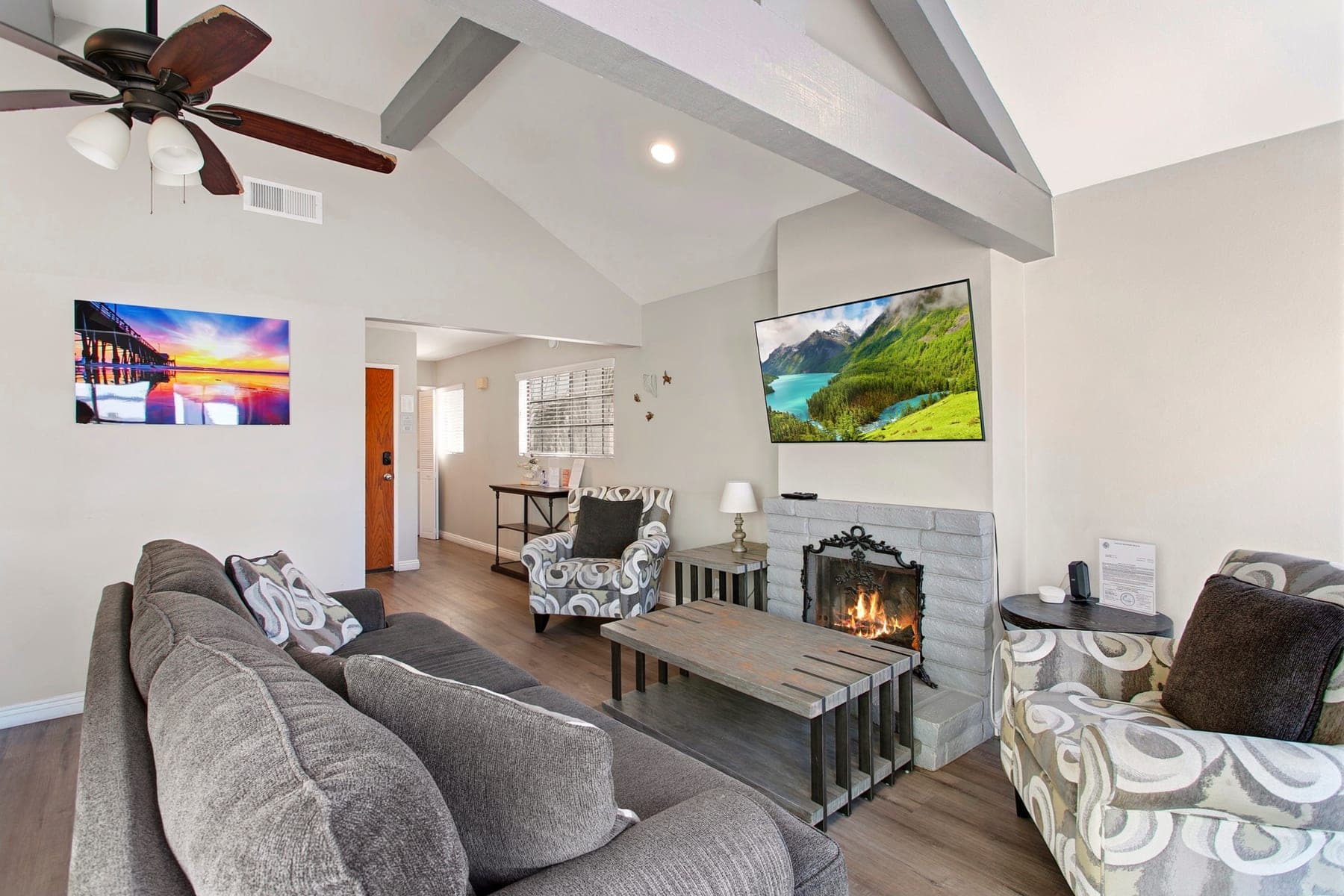 Living room reading chairs, fireplace, and balcony doors
