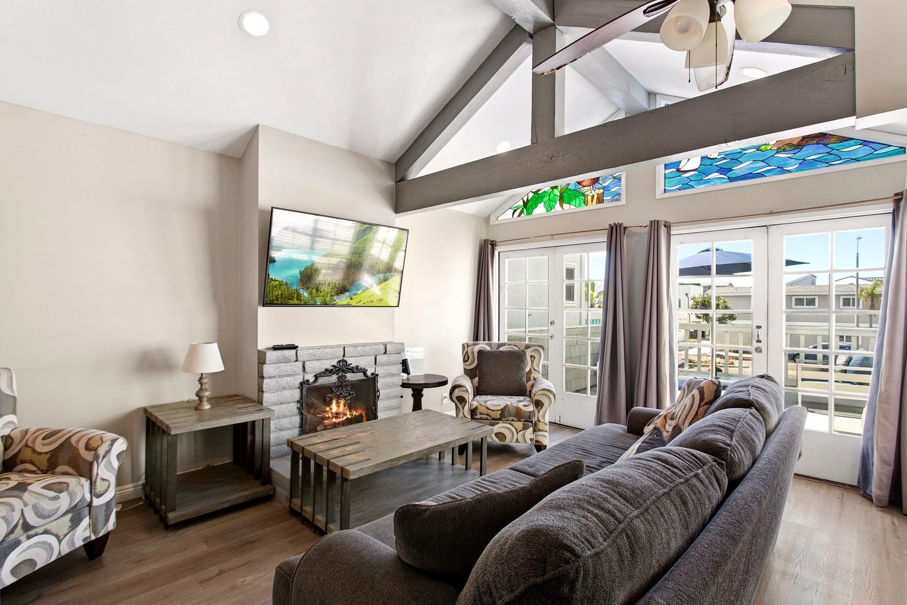 Living room sofa, fireplace, Smart TV, and balcony doors