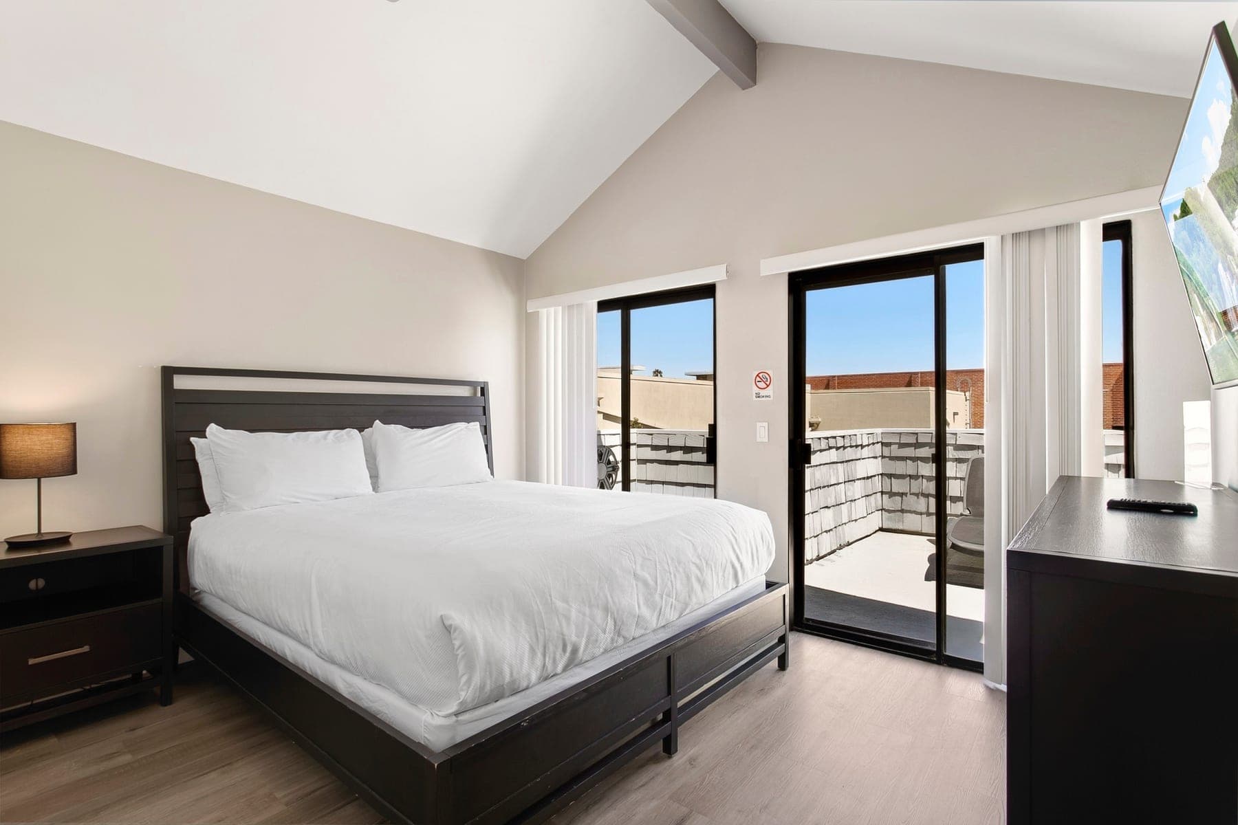 Primary Newport Beach bedroom with king bed and balcony access